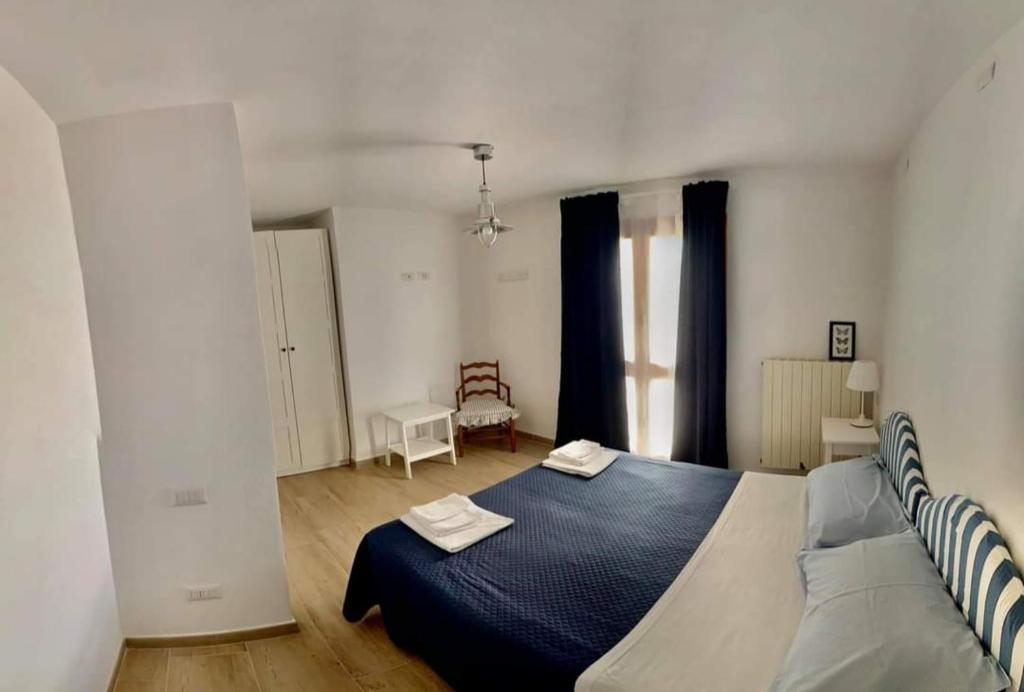 una camera bianca con letto blu di Casa sui Tetti a Ozieri