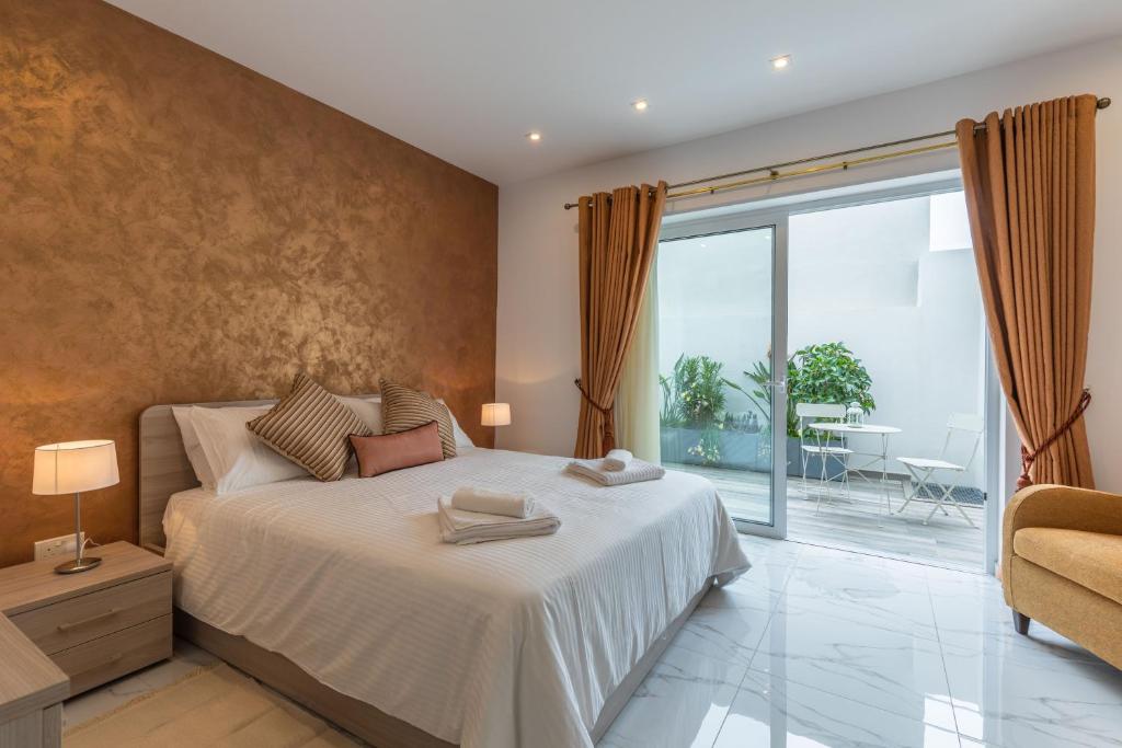 een slaapkamer met een bed en een groot raam bij White Sands in Mellieħa