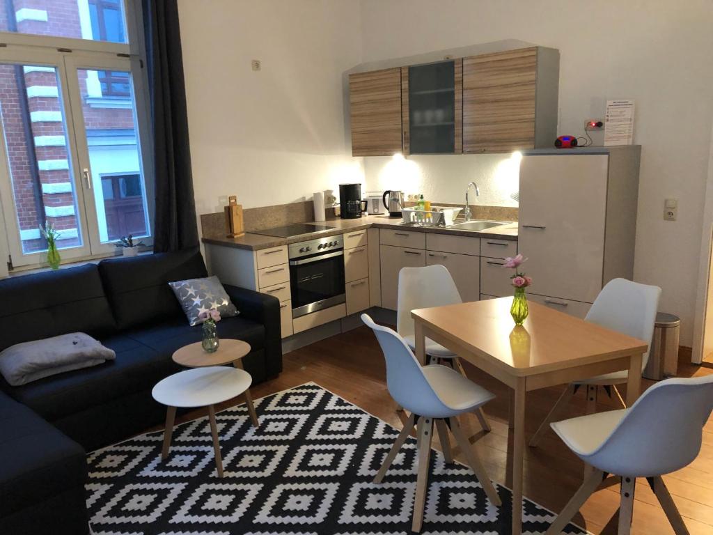 ein Wohnzimmer mit Couch und Tisch und eine Küche in der Unterkunft Apartment am Schelfmarkt in Schwerin