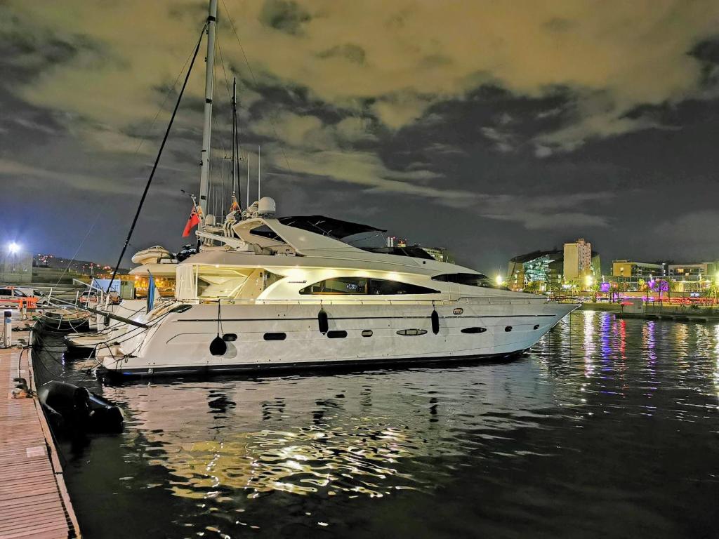 a white boat is docked in the water at night at Rent Luxury Motor Yacht in Barcelona