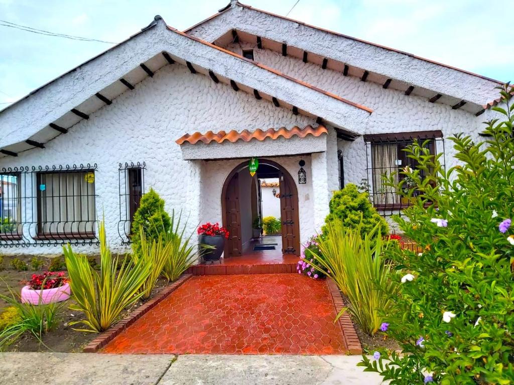 una pequeña casa blanca con entrada roja en Villa Suite Emanuel en Bogotá