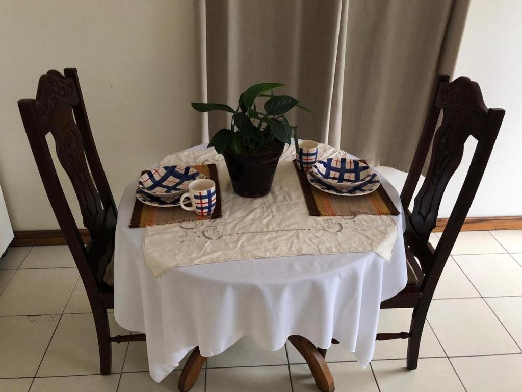 uma mesa com uma toalha de mesa branca e uma planta sobre ela em Open house em Manágua