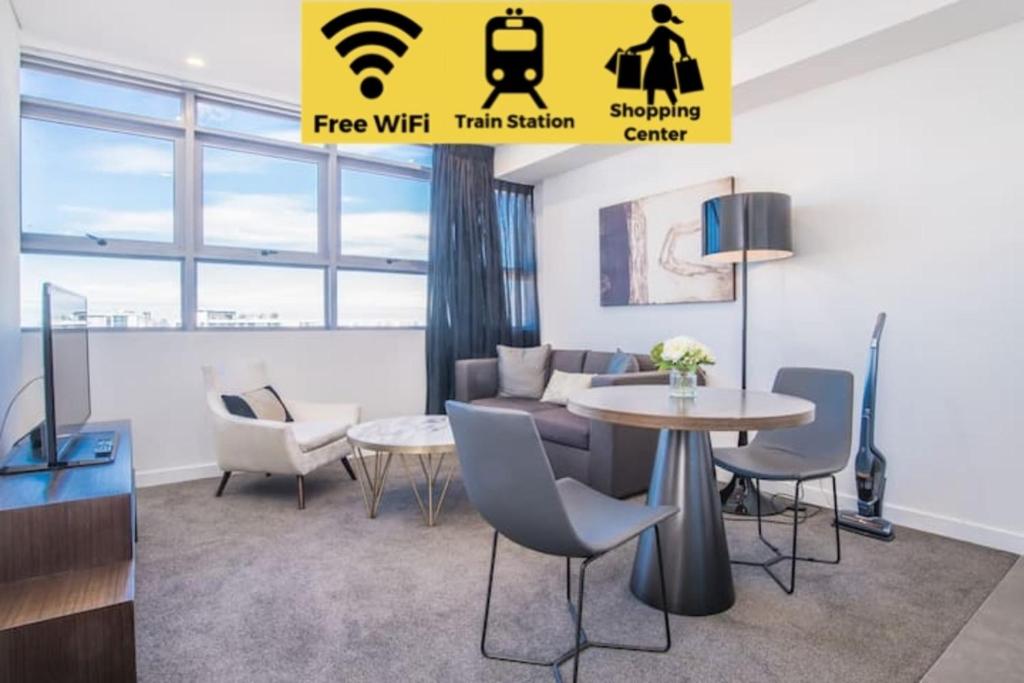 a living room with a table and chairs at Train Station Access! 1Bed1Bath APT at Chatswood in Sydney