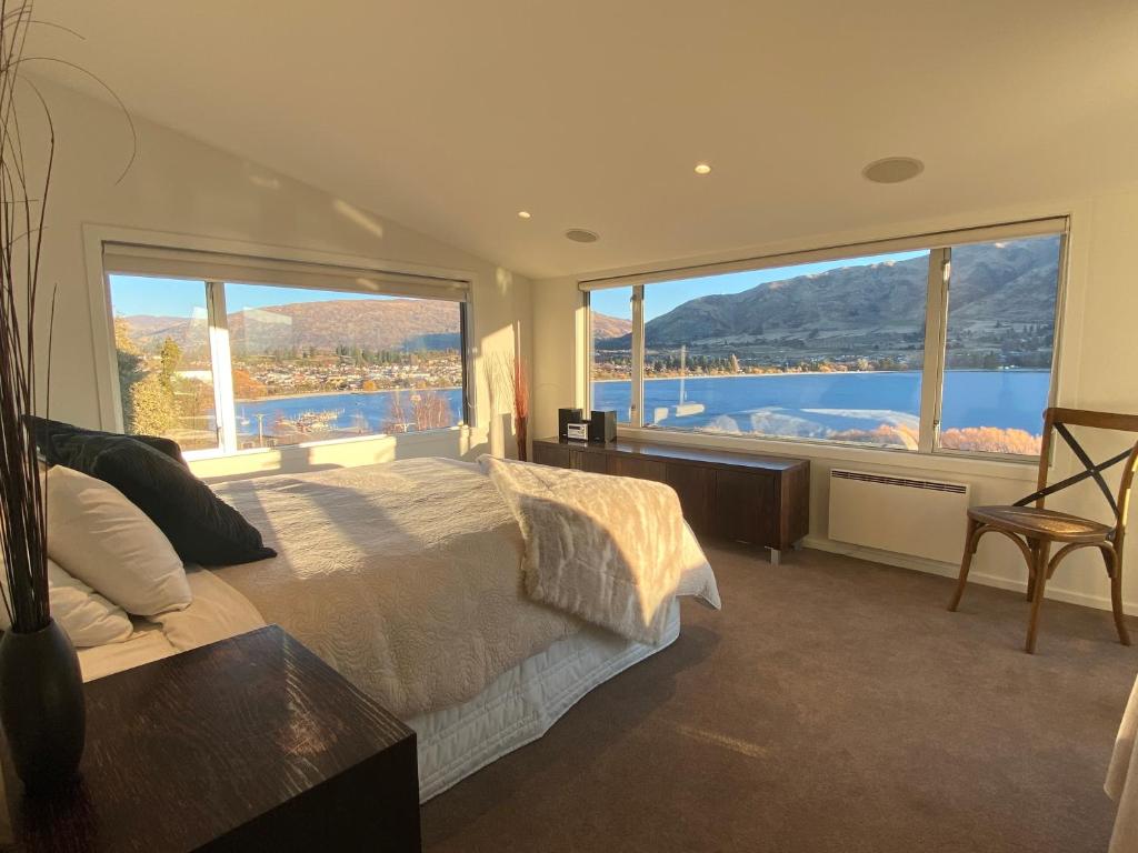 a bedroom with a large bed with a large window at Lakeview Heights Luxury Apartment 2 in Wanaka