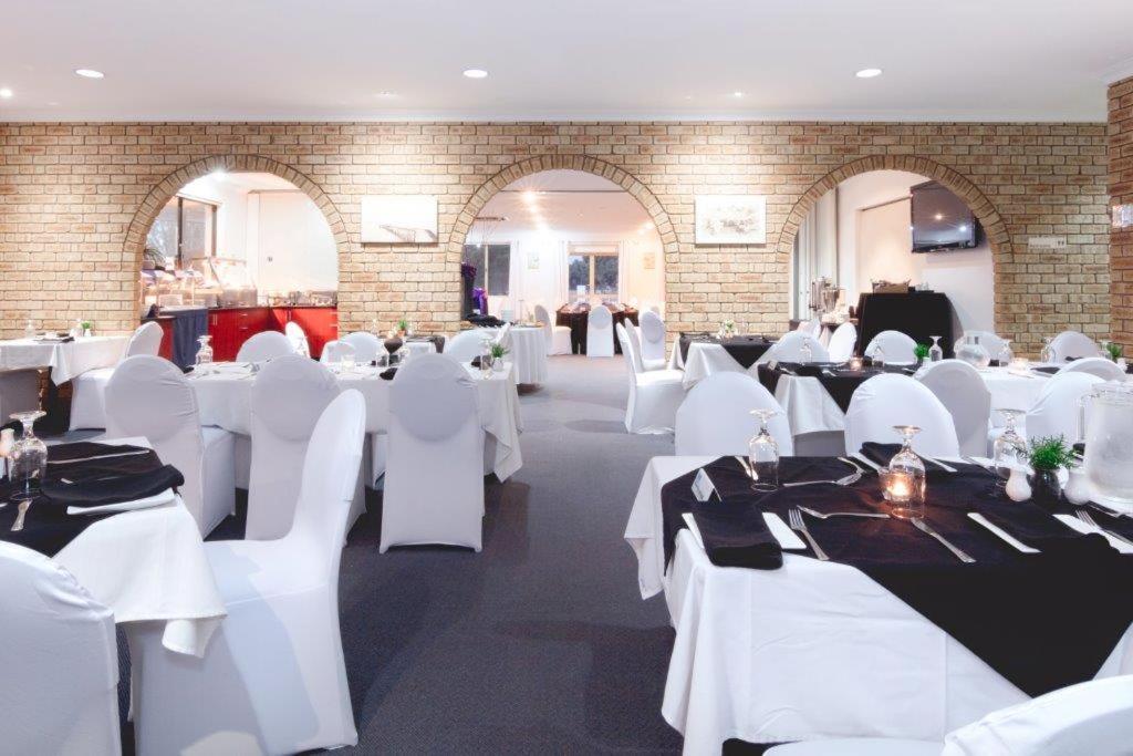 a banquet hall with white tables and white chairs at Pinnacles Edge Resort in Cervantes