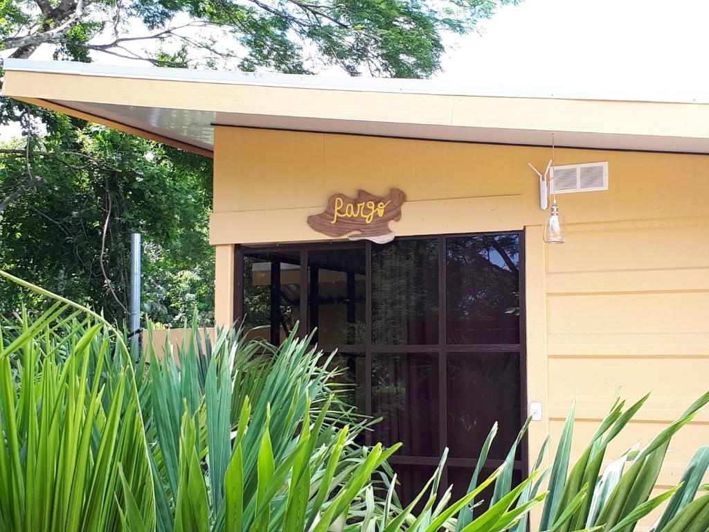 ein gelbes Gebäude mit einem Schild über einer Tür in der Unterkunft Chalet San Juanillo in San Juanillo