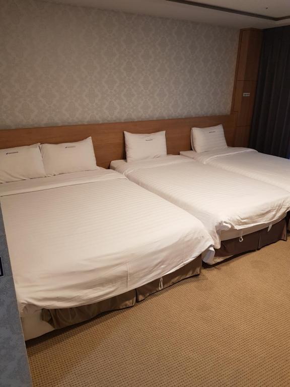 duas camas sentadas uma ao lado da outra num quarto em YangYang International Airport Hotel em Yangyang