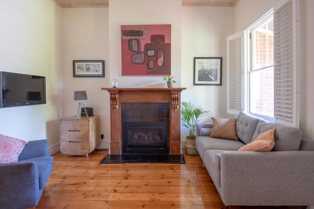 a living room with a fireplace and a couch at Mark and Kate's Place in Bendigo