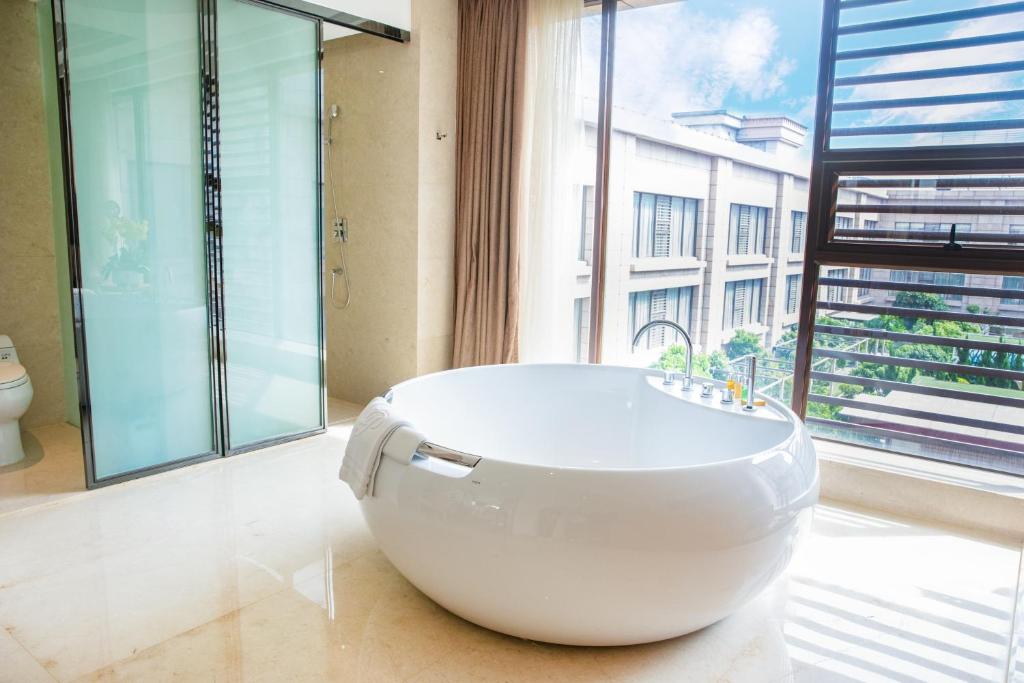 a large white bath tub in a bathroom with a window at Holiday Inn Foshan Nanhai Central, an IHG Hotel in Foshan