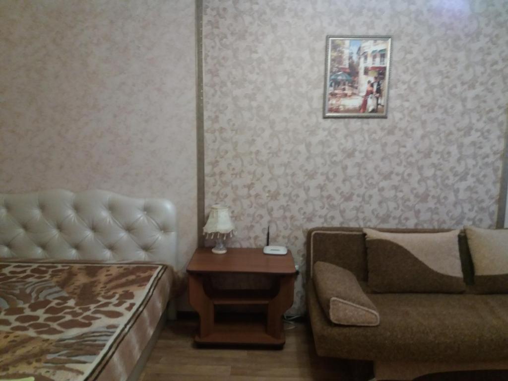 een woonkamer met een bank en een tafel bij Apartment Akademika Krilova 7 in Sevastopol