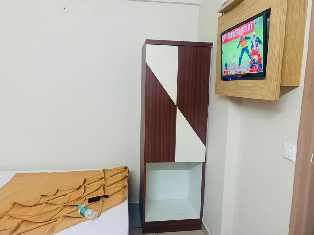 a room with a tv and a bed and a tvictericter at SAHARA Inn in Bangalore