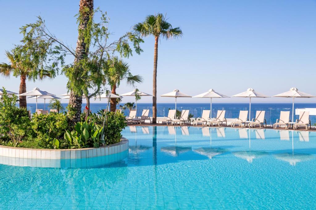 una piscina con sillas y sombrillas en un complejo en Atlantica SunGarden Beach, en Ayia Napa