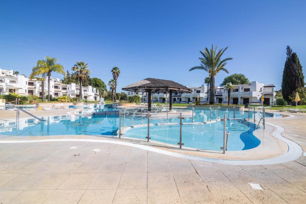 een groot zwembad in een resort met palmbomen bij Clube Albufeira Apartment in Albufeira