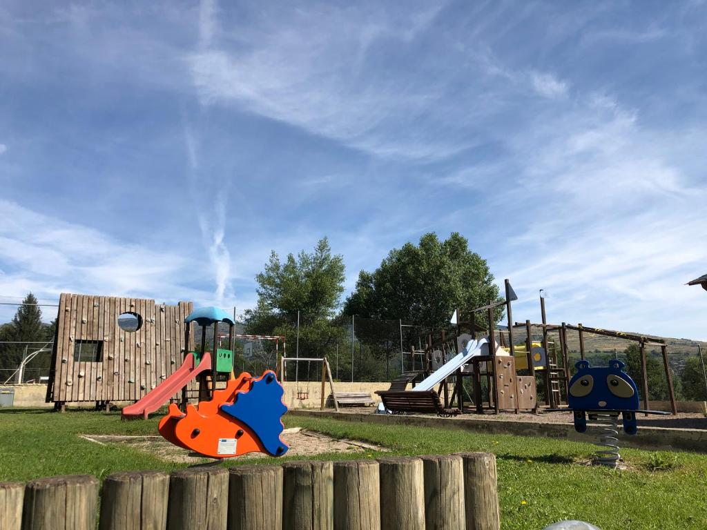 un parque con parque infantil con toboganes y estructura de juegos en Bungalows Pirineus, en Puigcerdà