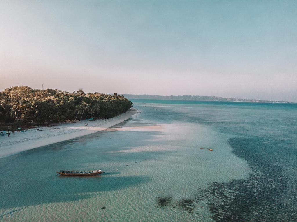 an aerial view of a beach with a boat in the water at Munjoh Ocean Resort - Private Beachfront Luxury Retreat in Havelock in Havelock Island