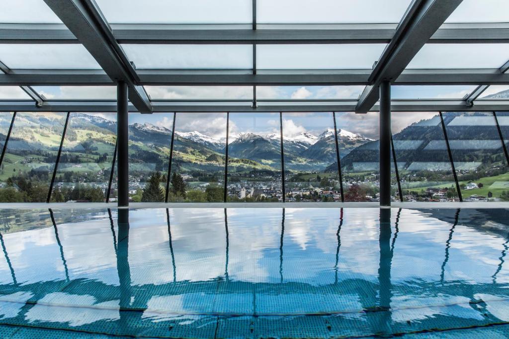 a swimming pool with a view of mountains at Lebenberg Schlosshotel-Kitzbühel in Kitzbühel