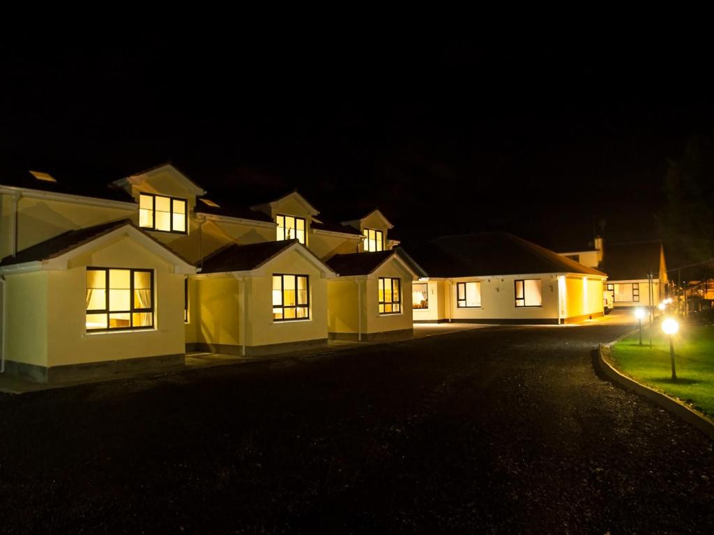 uma fila de casas iluminadas à noite em Hillview Self Catering em Lusk