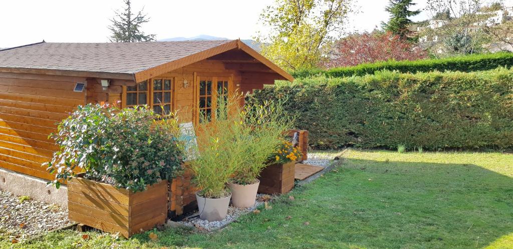 un pequeño cobertizo de madera con plantas en un patio en Chalet des Mésanges en Annonay