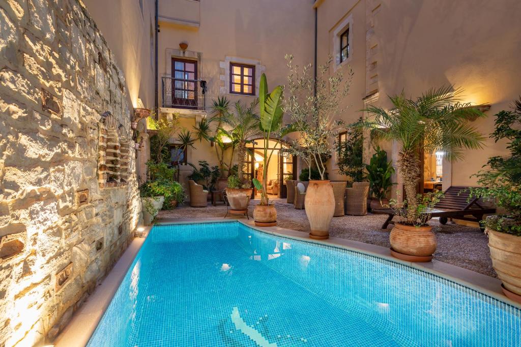 a swimming pool in the middle of a house with plants at Palazzino Di Corina in Rethymno Town