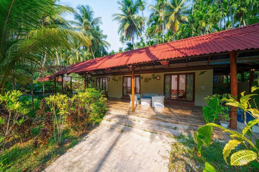 a house with a red roof and a patio at Munjoh Ocean Resort - Private Beachfront Luxury Retreat in Havelock in Havelock Island
