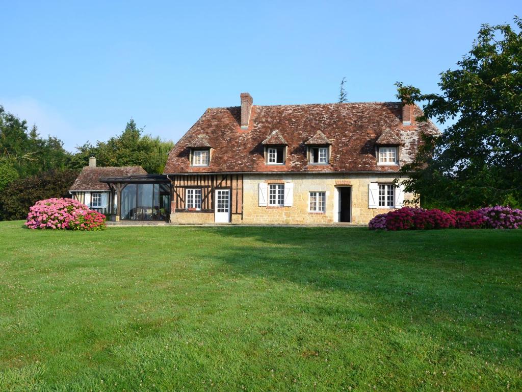 uma grande casa de tijolos com um grande quintal em Maison d'Hôtes la Bihorée em Lisieux