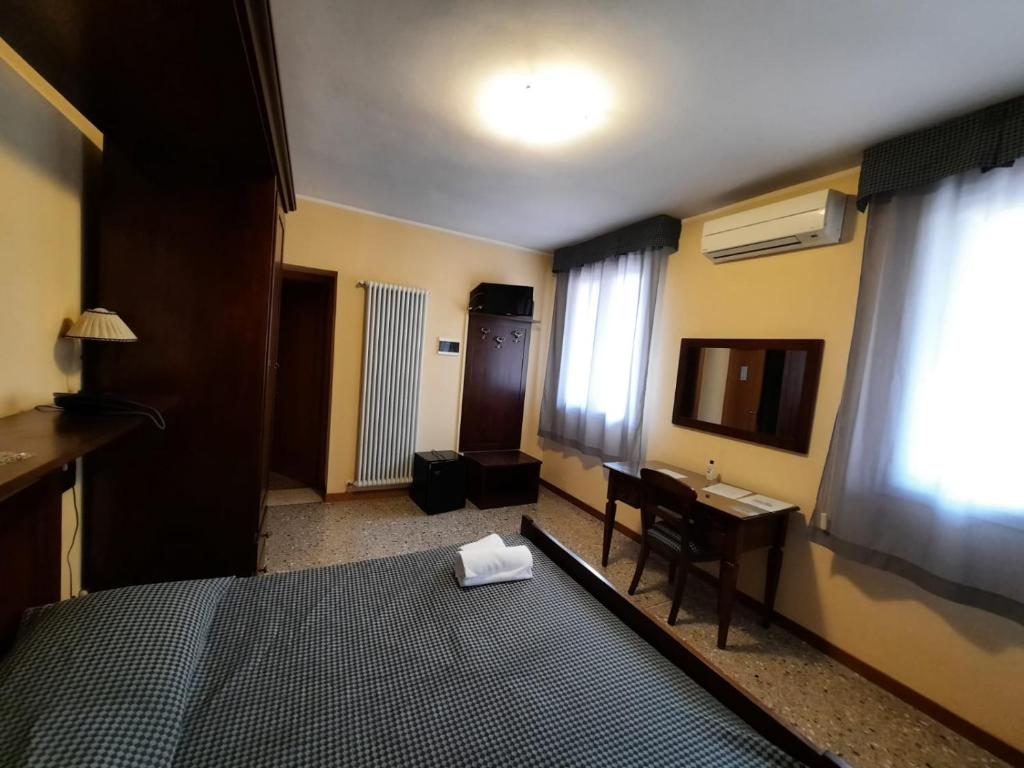 a bedroom with a bed and a desk and a television at osteria canal 1803 in Borso del Grappa