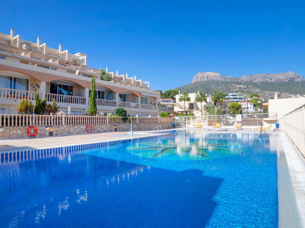 una gran piscina azul frente a un edificio en Apartment Cala Manzanera-2 by Interhome, en Calpe