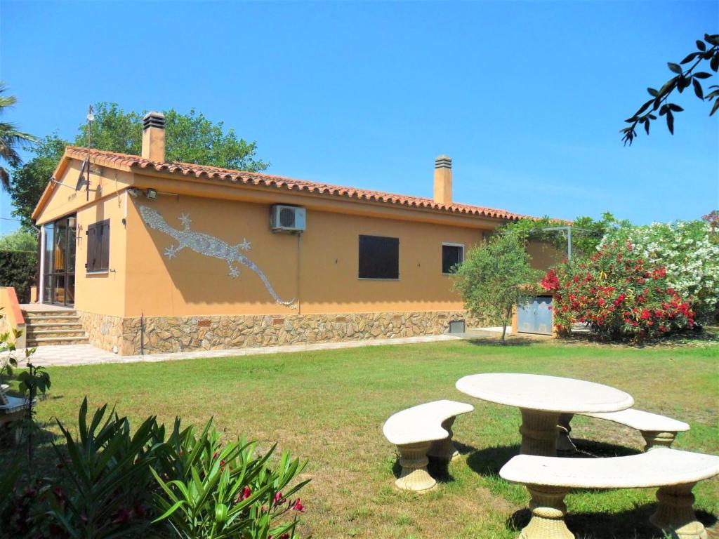 una casa con dos mesas de picnic en un patio en Holiday Home Don Felipe by Interhome en Sant Martí d’Empúries