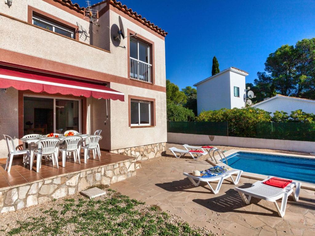 une maison avec une terrasse et une piscine dans l'établissement Holiday Home Villa Santa Marta IV by Interhome, à Les tres Cales