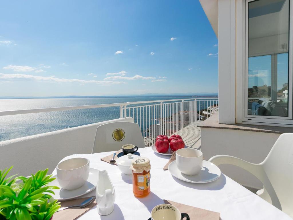 ロザスにあるHoliday Home Jeroni Pau by Interhomeの海を望むバルコニー(テーブル、カップ、プレート付)