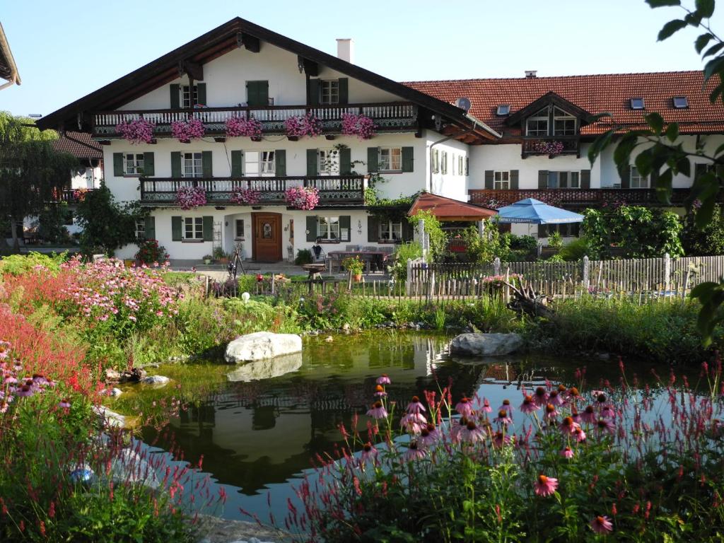 una casa con un estanque frente a un jardín en Wachingerhof, en Bad Feilnbach