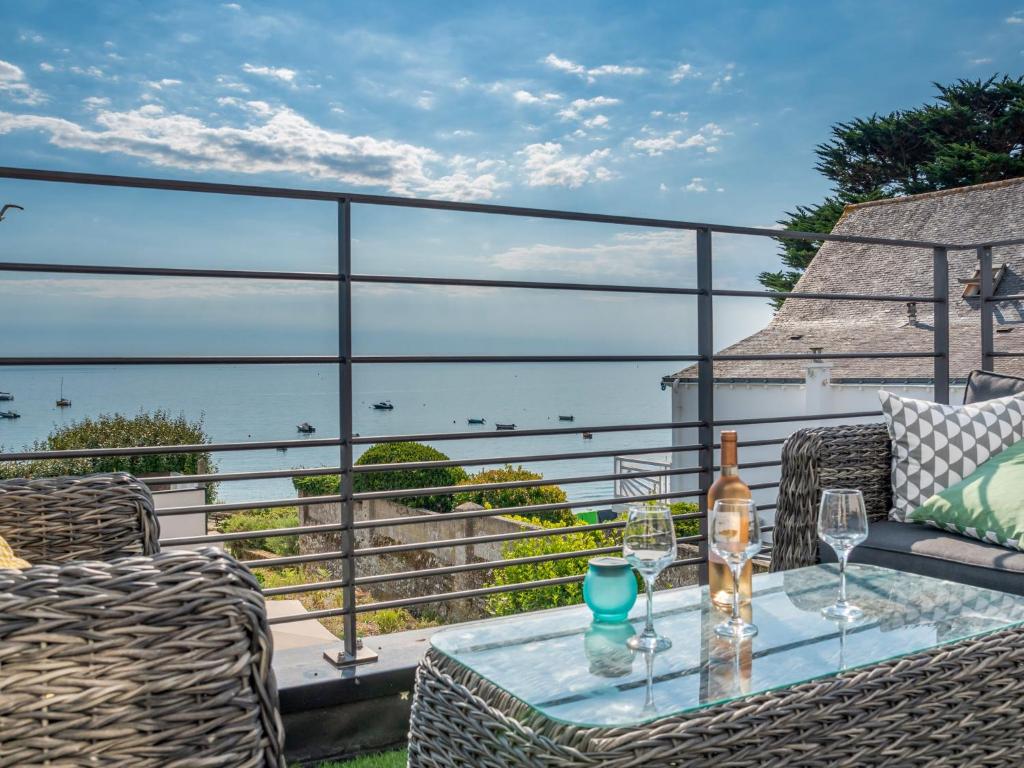- une table avec des verres à vin sur un balcon donnant sur l'océan dans l'établissement Holiday Home Villa Kerhostin by Interhome, à Kerhostin