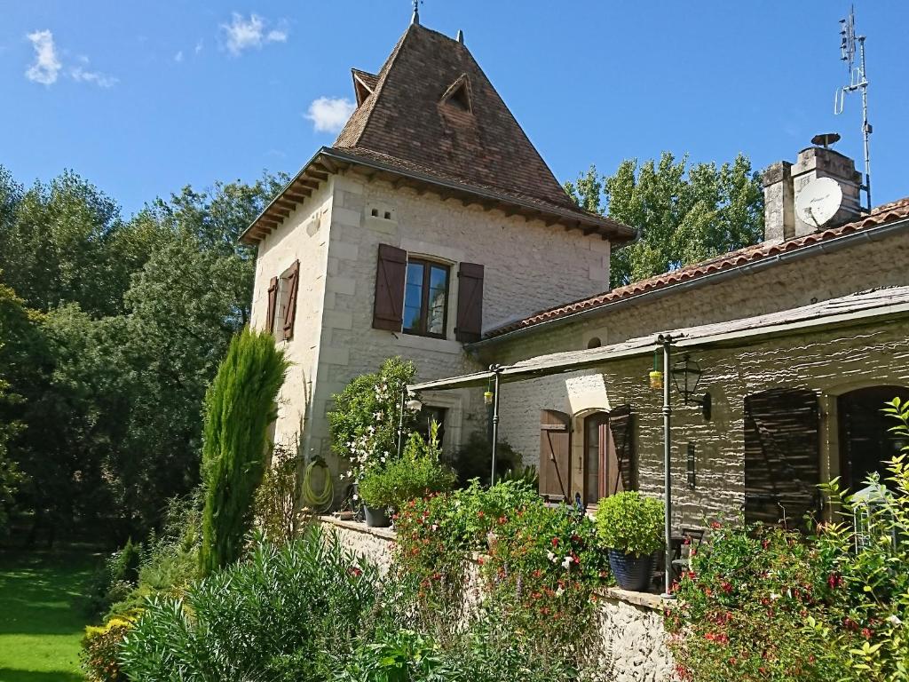 una vecchia casa con una torre sopra di Moulin Rouhaud a Montboyer