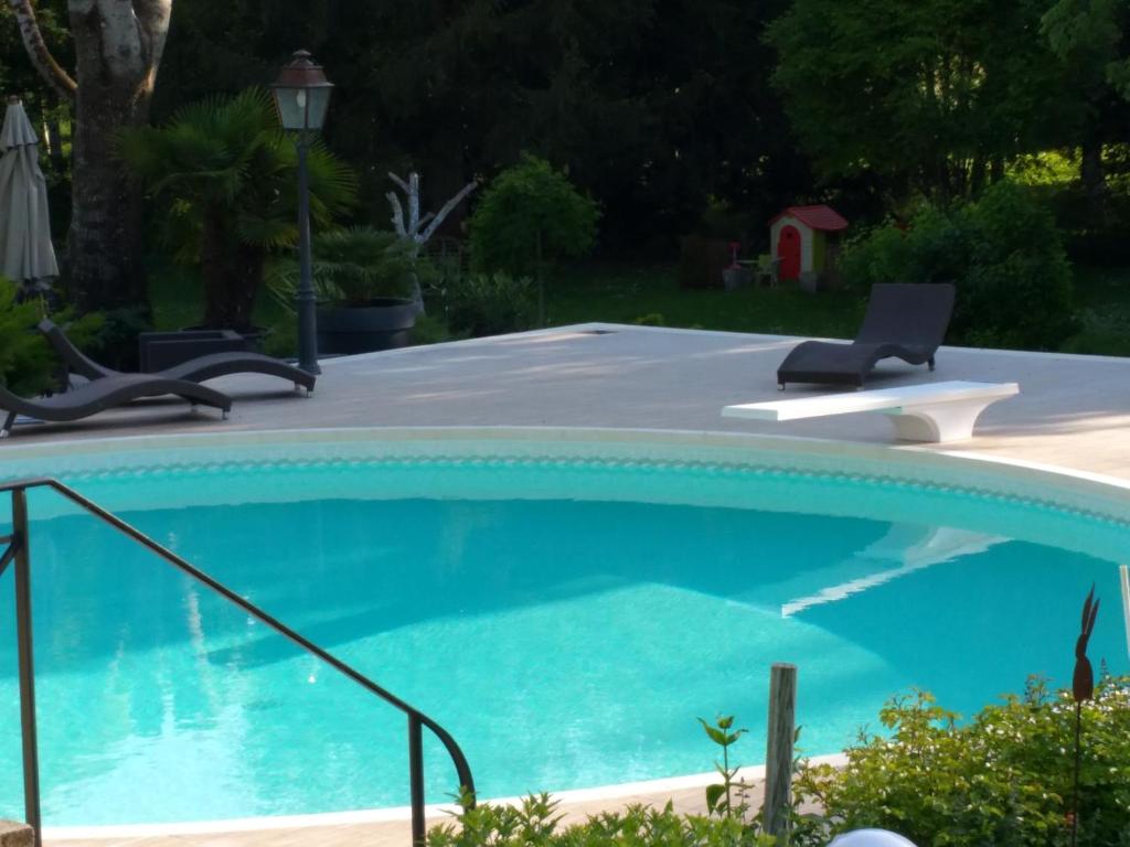 a large blue swimming pool with two chairs in a yard at Moulin Rouhaud in Montboyer