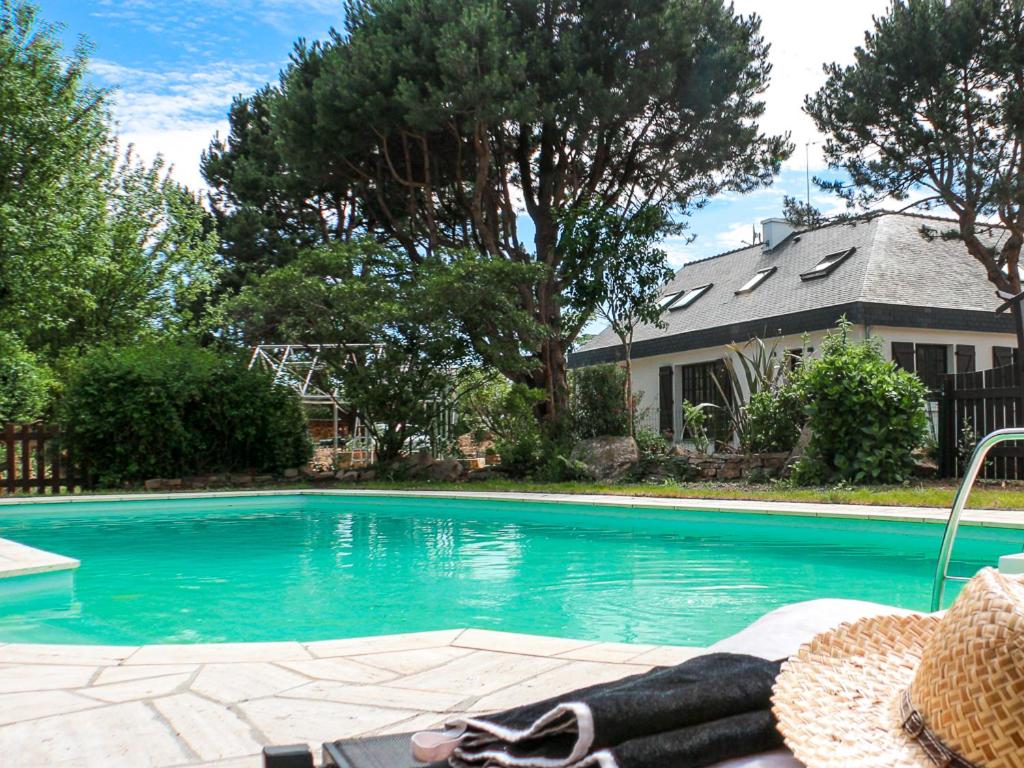 una piscina en un patio con una casa en La Dolce Vita, en Fouesnant