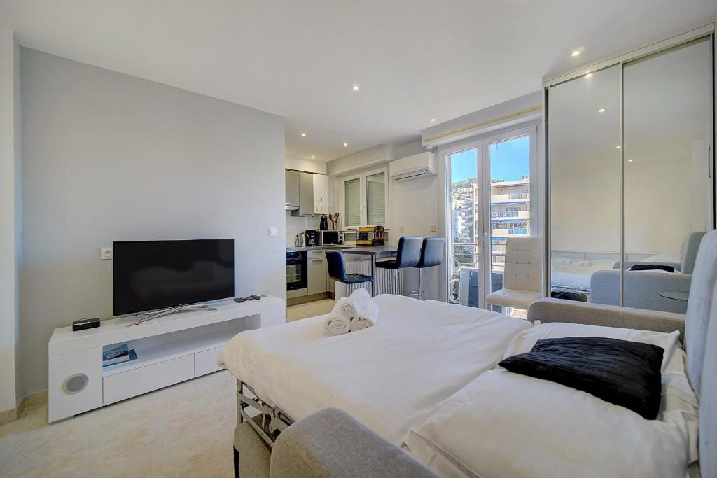 un salon avec un lit et une télévision à écran plat dans l'établissement IMMOGROOM - Cozy - Cannes Center - AC in living room - Close to the sea, à Cannes