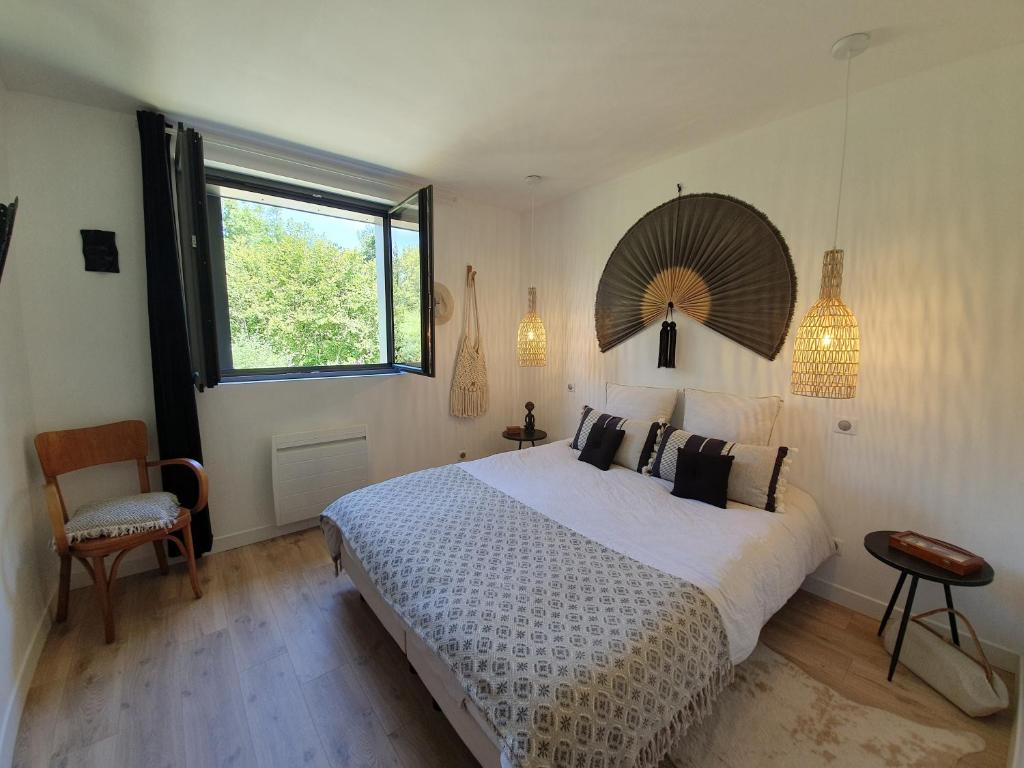 a bedroom with a large bed and a window at "Au jardin sur l'eau" in Amiens