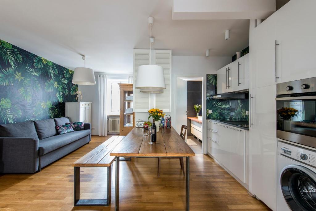 eine Küche und ein Wohnzimmer mit einem Tisch und einem Sofa in der Unterkunft Mozart Apartment München in München