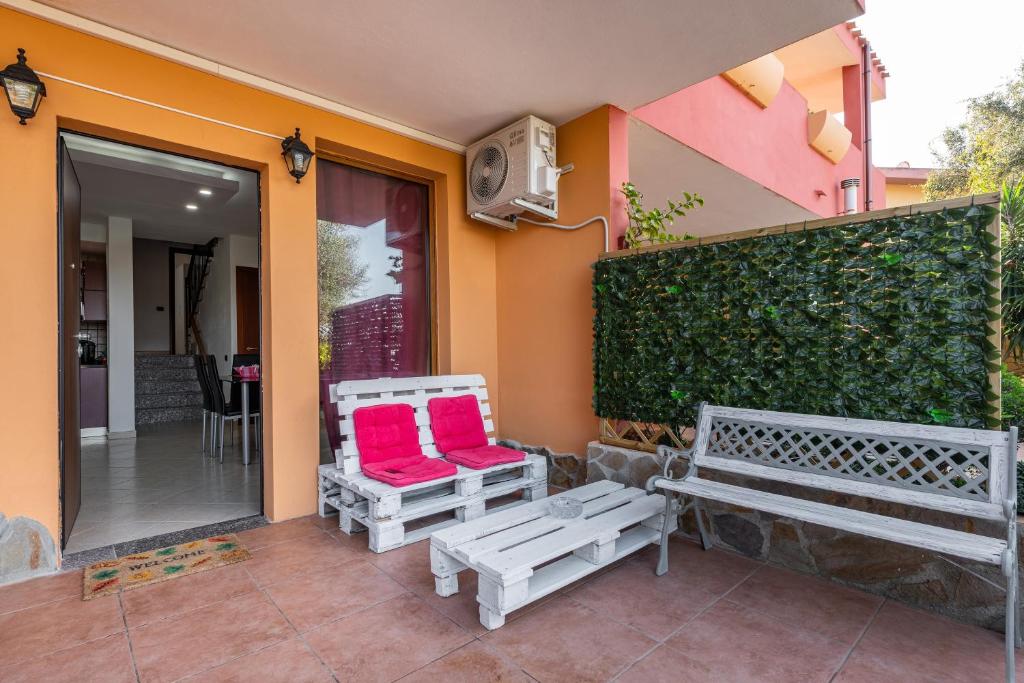 dos bancos sentados fuera de una casa con cojines rojos en Villa Sunshine, en Capitana