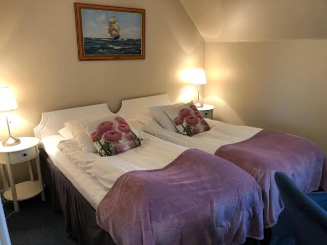 a bedroom with two beds with pink flowers on them at Hotell Turistgården i Simrishamn in Simrishamn