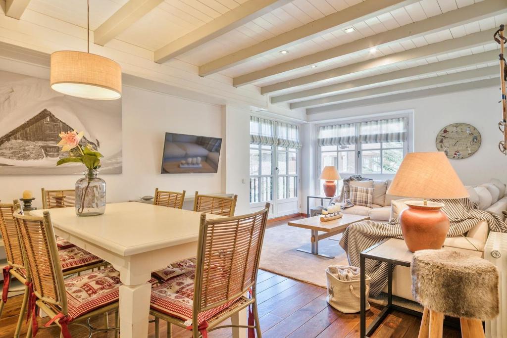 a dining room and living room with a table and chairs at Luderna - Apartamento Val de Ruda B82 Dera Mèu in Naut Aran