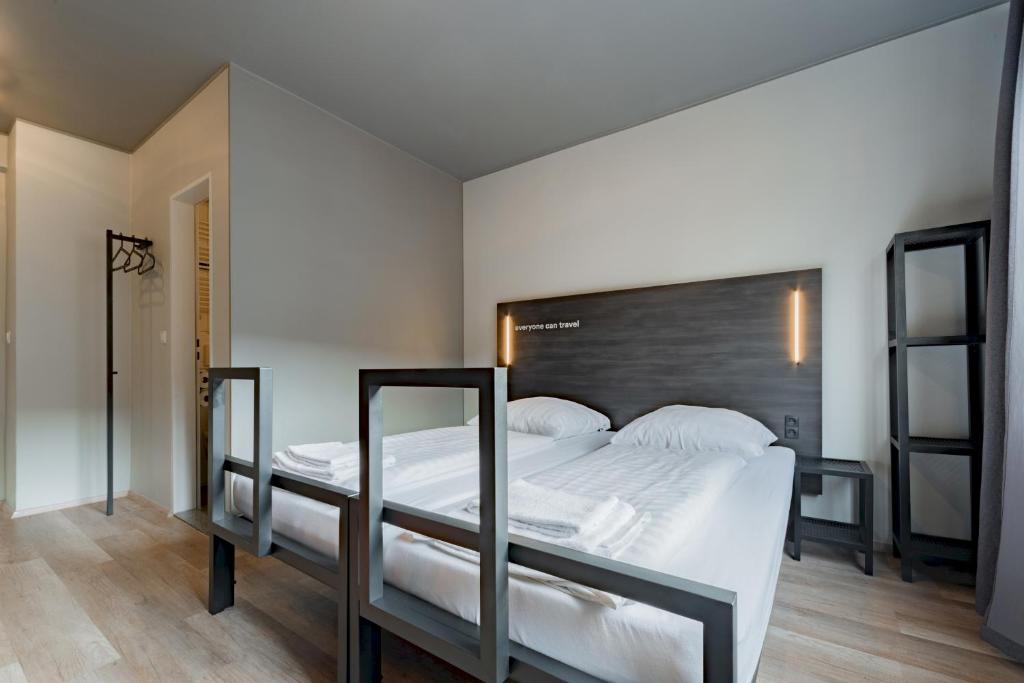 ein Schlafzimmer mit einem großen Bett mit weißen Laken und Kissen in der Unterkunft a&o Köln Dom in Köln