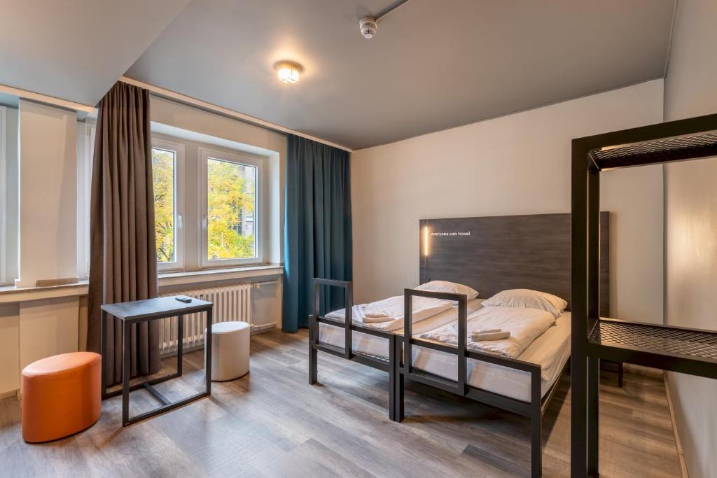 a bedroom with a bunk bed and a table at a&o Köln Hauptbahnhof in Cologne