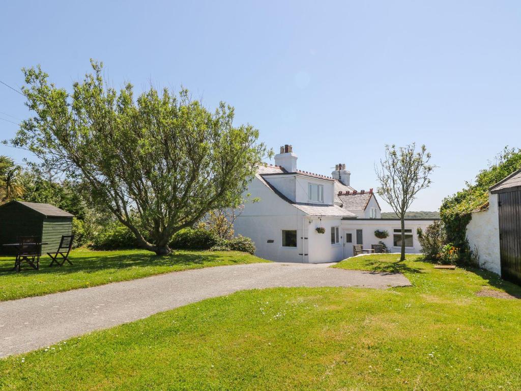 a road leading to a white house with a bench at Charming 2 Bed House near Rhoscolyn DISCOUNTS FOR in Holyhead