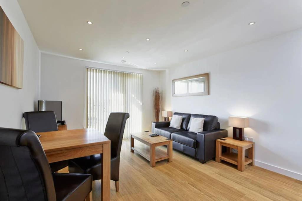ein Wohnzimmer mit einem Sofa und einem Tisch in der Unterkunft MODERN APARTMENT at SLOUGH STATION, LONDON IN 18 MINS! in Slough