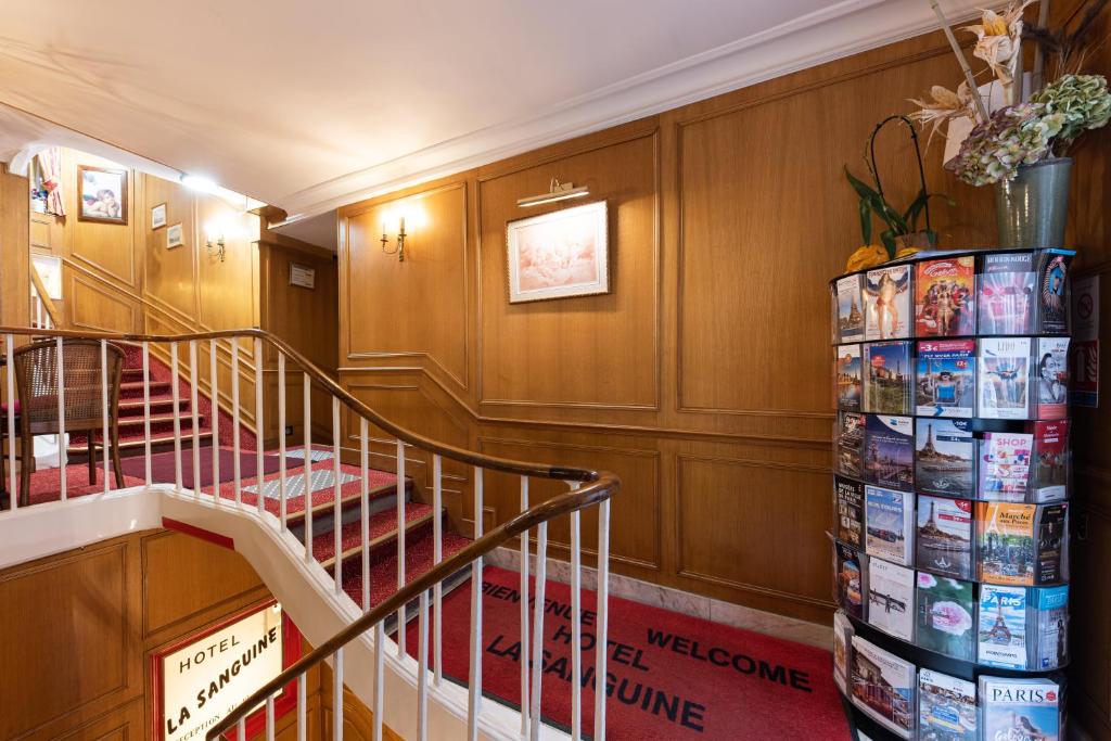 a staircase in a building with a bunch of magazines at Hôtel La Sanguine in Paris