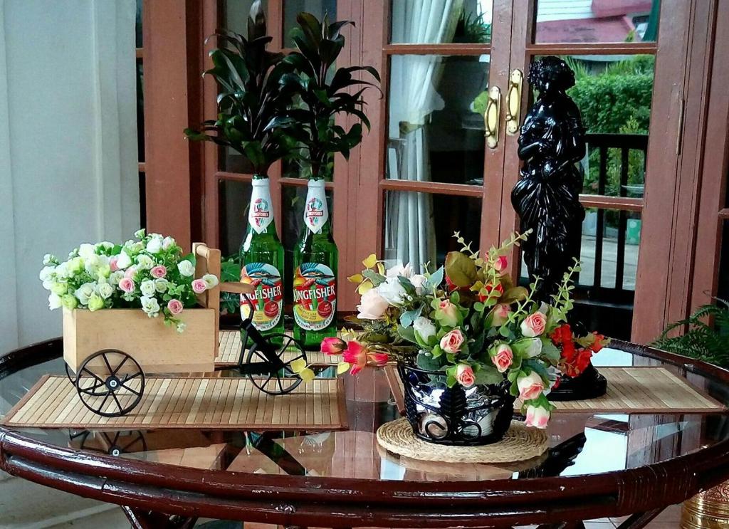 a table with two soda bottles and flowers on it at Golaghat Gymkhana in Golāghāt