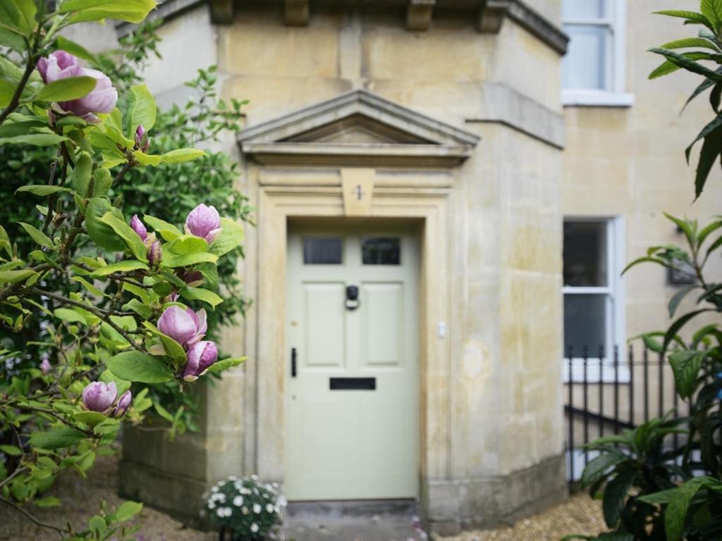 a white door of a building with flowers at Percy Place Bath in Bath