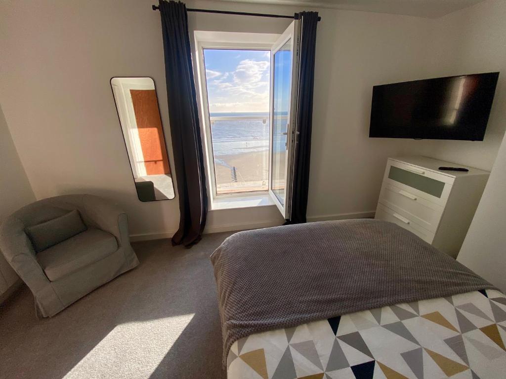1 dormitorio con cama y ventana con vistas a la playa en Bridlington Bay Apartments, en Bridlington