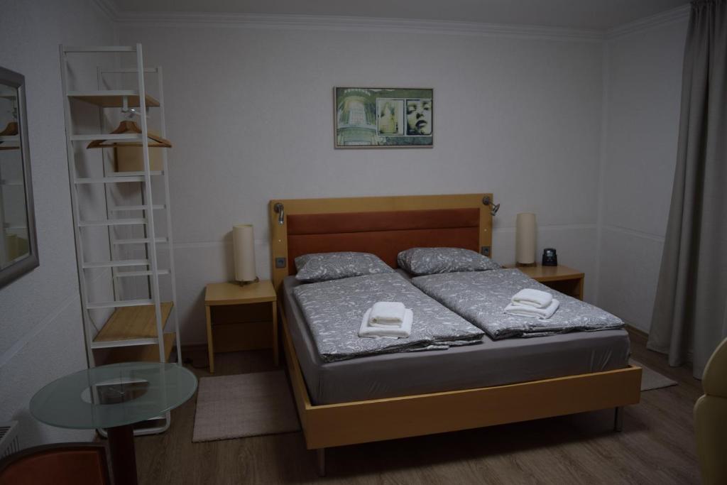 Dormitorio pequeño con cama y mesa en Gasthof Bittner en Meinerzhagen